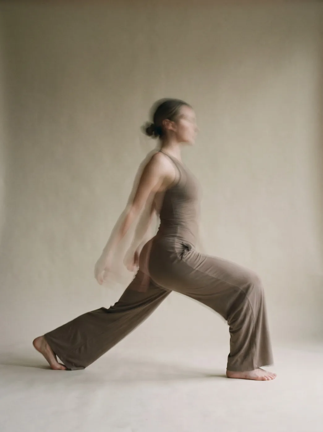A figure flowing through a slow lunge, dissolving into motion